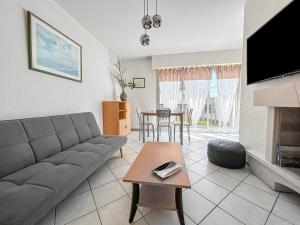 a living room with a couch and a table at La Pause Cabourgeaise in Cabourg