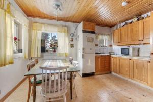 a kitchen with a table and a dining room at Traditional wooden house at the lake in Jokkmokk