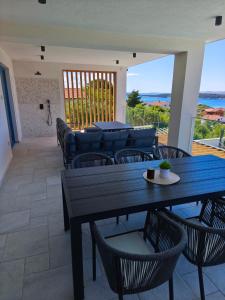 a patio with a table and chairs and a couch at Villa Milamar in Banjol