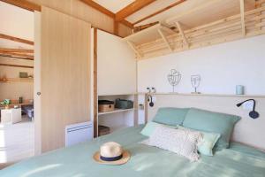 a bedroom with a bed with a hat on it at Camping - Piscine - ccbbdag in Vic-sur-Cère +91 photos