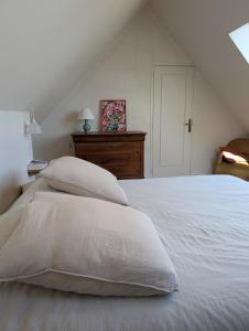 a white bed with white sheets and pillows at Korrigan Cove maison 8 personnes Saint Benoit in Saint-Benoît-des-Ondes