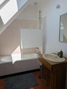 a bathroom with a sink and a bath tub at Korrigan Cove maison 8 personnes Saint Benoit in Saint-Benoît-des-Ondes