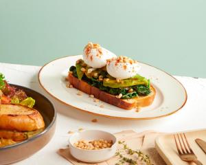 a plate of food with eggs on top of a sandwich at Sindhorn Midtown Hotel Bangkok, Vignette Collection by IHG in Bangkok