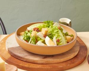 a salad in a bowl on a wooden table at Sindhorn Midtown Hotel Bangkok, Vignette Collection by IHG in Bangkok