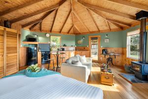une chambre avec un grand lit et une cuisine dans l'établissement Mavista Cottage, à Adventure Bay