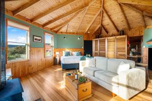 un salon avec un canapé et un lit dans l'établissement Mavista Cottage, à Adventure Bay