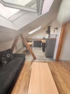 Una sala de estar con un sofá y una cocina. en Wood loft by Mulhouse, en Mulhouse
