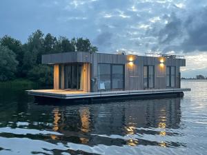 a tiny house on a dock on the water at The Sustainable Saek Sneekermeer in Sneek