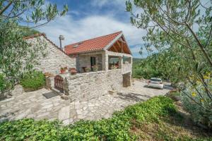 a stone house with a car parked in front of it at House Radojka in Tisno