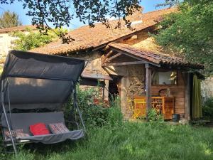 a chair sitting in the grass in front of a house at Chambre insolite in Saint-Mathieu