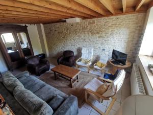 salon z kanapą, krzesłami i telewizorem w obiekcie La Grange - Charmante maison à Langrune-sur-mer w mieście Langrune-sur-Mer