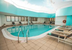 a large swimming pool in a large building at Holiday Inn Abu Dhabi by IHG in Abu Dhabi