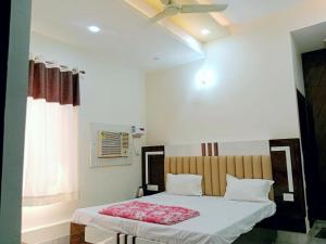 范兰德凡Hotel Dev Shri Residency ! near Prem mandir & ISCKON ! Fully AC rooms ! Café & Banquet, Free parking & Lift availability的带床和天花板的卧室