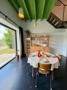 a dining room with a table and some chairs at La Maisonnette in Templeuve