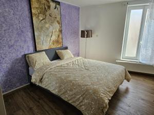 蒙斯magnifique appartement à Mons的一间卧室配有一张紫色墙壁的床