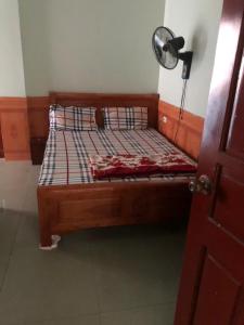 a wooden bed in a room with a fan at Nhà nghỉ 868 in Kon Rung (1)