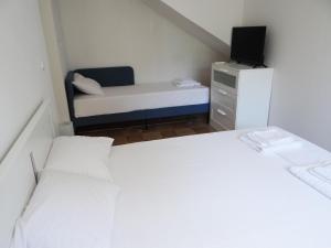 a small room with two beds and a tv at Kalogeriko in Polychrono