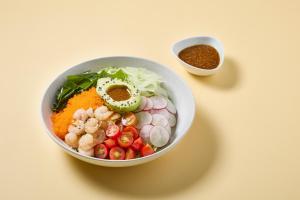 a bowl of food with vegetables and a sauce at Days Inn by Wyndham Patong Beach in Patong Beach