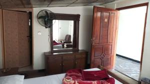 a bedroom with a mirror and a wooden dresser at white onion hotel and restaurant in Murree