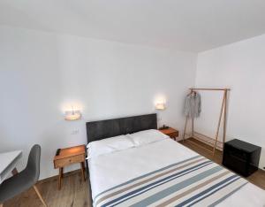 a bedroom with a bed and two lights on the wall at Sea View Affittacamere Riomaggiore in Riomaggiore
