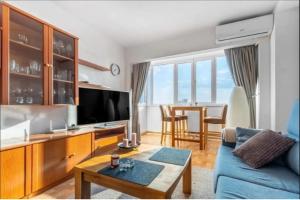 a living room with a blue couch and a tv at Torreblanca E&S in Torrevieja
