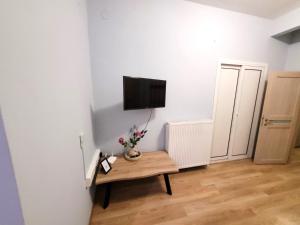 a room with a table with a tv on a wall at Metropole Vibe by GOLDENLAND in Thessaloniki