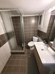 a bathroom with a shower and a toilet and a sink at Metropole Vibe by GOLDENLAND in Thessaloniki