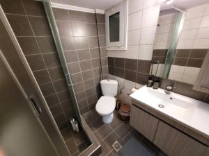 a bathroom with a toilet and a sink and a shower at Metropole Vibe by GOLDENLAND in Thessaloniki