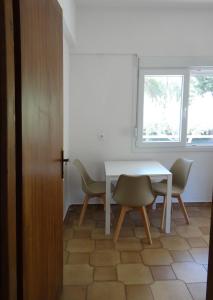a dining room with a white table and chairs at Kalogeriko in Polychrono
