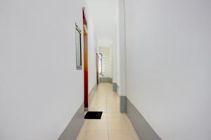 a hallway with white walls and a tile floor at Hotel O Medan near Universitas Sumatera Utara formerly Surya Residence in Sunggal +22 photos