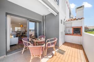 Un comedor con mesa y sillas en un balcón. en Casa Ela Navega, en Aljezur
