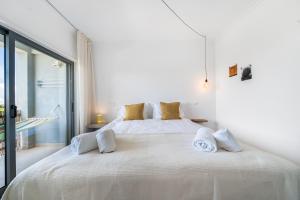 1 dormitorio blanco con 1 cama blanca grande con almohadas en Casa Ela Navega, en Aljezur