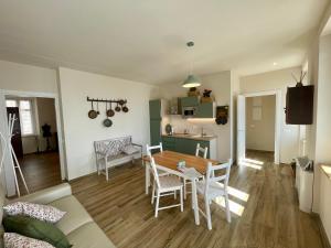 a living room with a table and chairs and a kitchen at Casa Bordesini in La Morra
