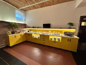 a kitchen with yellow cabinets and yellow counters at Boutique Hotel Sopianae in Pécs +48 photos