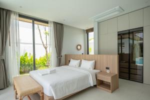 a bedroom with a white bed and a large window at Mouana Breeze Mai Khao 4-bedroom Pool Villa 9925 in Mai Khao Beach +67 photos