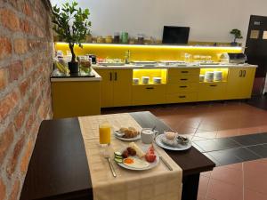 a kitchen with a table with breakfast foods and orange juice at Boutique Hotel Sopianae in Pécs