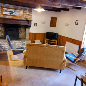 ein Wohnzimmer mit Couch und Kamin in der Unterkunft Gite Les Renardières en Bretagne Romantique proche in Saint-Pierre-de-Plesguen