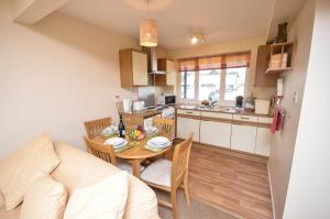 a kitchen and dining room with a table and chairs at Rebel in Wroxham