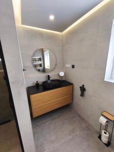 a bathroom with a black sink and a mirror at Villa Milamar in Banjol
