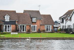 a row of houses next to a river at Rebel in Wroxham