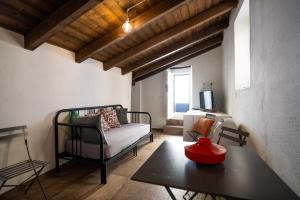 a living room with a couch and a table at Sardinian Gallery Domus Historic Rooms & Apartments in Bosa