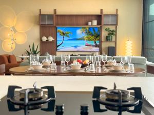 Un comedor con una mesa y un televisor en la pared. en Villa La Lay, en Ban Tai