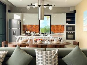 cocina y comedor con sofá y mesa en Villa La Lay, en Ban Tai