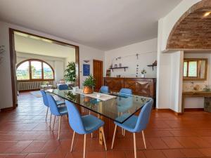 a dining room with a glass table and blue chairs at Casa Terra Holiday in Padenghe sul Garda