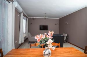 Un jarrón de flores sobre una mesa en una sala de estar. en Niza Homes, Pool, No Blackouts & Walk to Munali Mall, en Lusaka