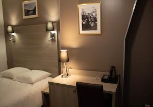 a hotel room with a bed and a desk with a lamp at Paris Rooms & Dreams Hotel in Paris