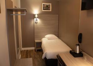 a small bedroom with a bed and a table at Paris Rooms & Dreams Hotel in Paris