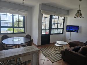 a living room with a couch and a table at Winahost Vionta en Primera Línea de Mar in Ribeira
