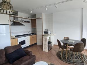 a kitchen and living room with a table and chairs at Winahost Vionta en Primera Línea de Mar in Ribeira