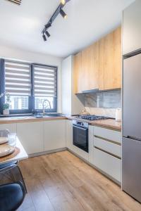 a kitchen with white appliances and wooden cabinets at Blvd Ivory Pipera Studio 43A in Voluntari +18 photos